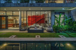 A modern house with a glass facade, a red accent wall, a staircase, and a pool area. - Villa Jungalow 2BR Pool Villa Near Beach Café del Mar & Padel (Canggu)