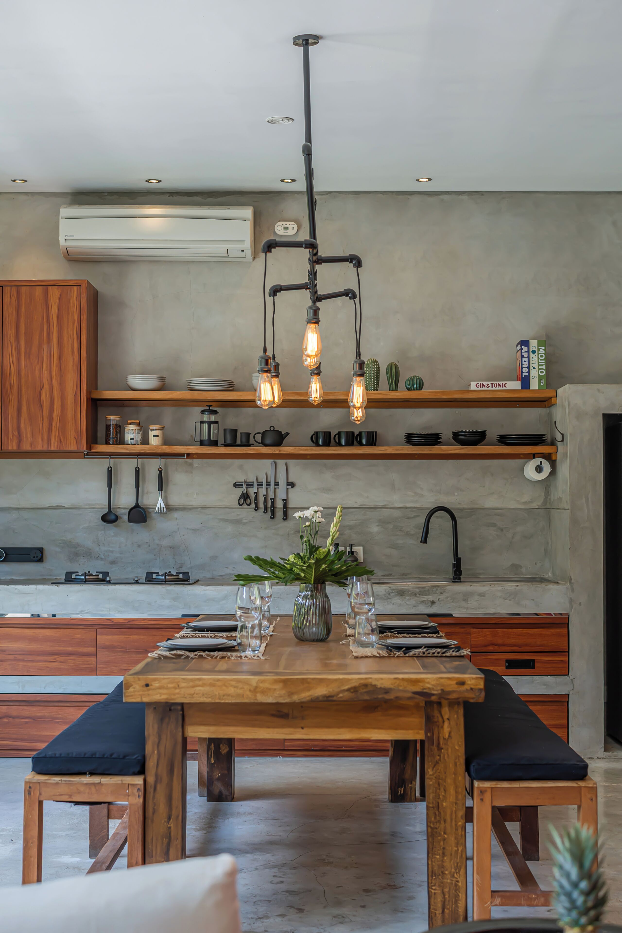 Una cocina moderna con armarios de madera, una isla central y lámparas colgantes.