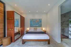 A bedroom with a large bed, wooden headboard, a world map on the wall, and two bedside lamps. - Villa Jungalow 2BR Pool Villa Near Beach Café del Mar & Padel (Canggu)
