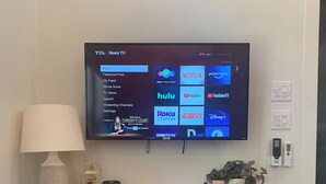 Un televisor de pantalla plana montado en la pared que muestra una interfaz de servicio de transmisión con varios iconos de aplicaciones.