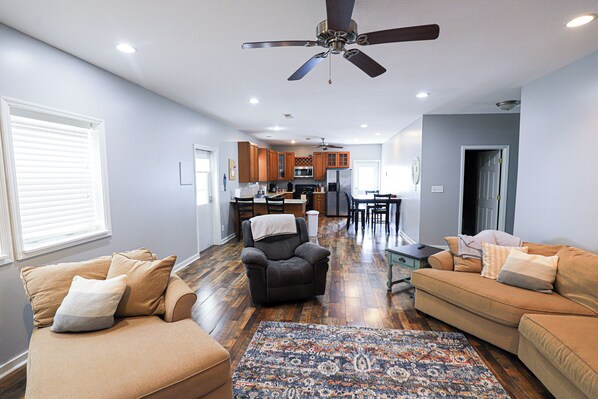 Relax in this inviting living area with a comfortable sofa, armchair, and patterned rug.