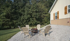 Relax in the serene outdoor seating area, surrounded by lush greenery and a charming wooden table.