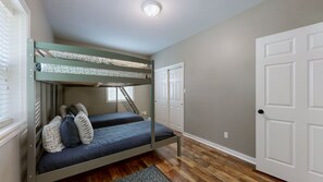 A bunk bed room with a window, a door, and a patterned rug. - Spacious Home in Moors Community on KY Lake with Outdoor Hot Tub and Fire Pit (Gilbertsville)