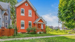 A red brick house with a front porch and a number '43' on the door.