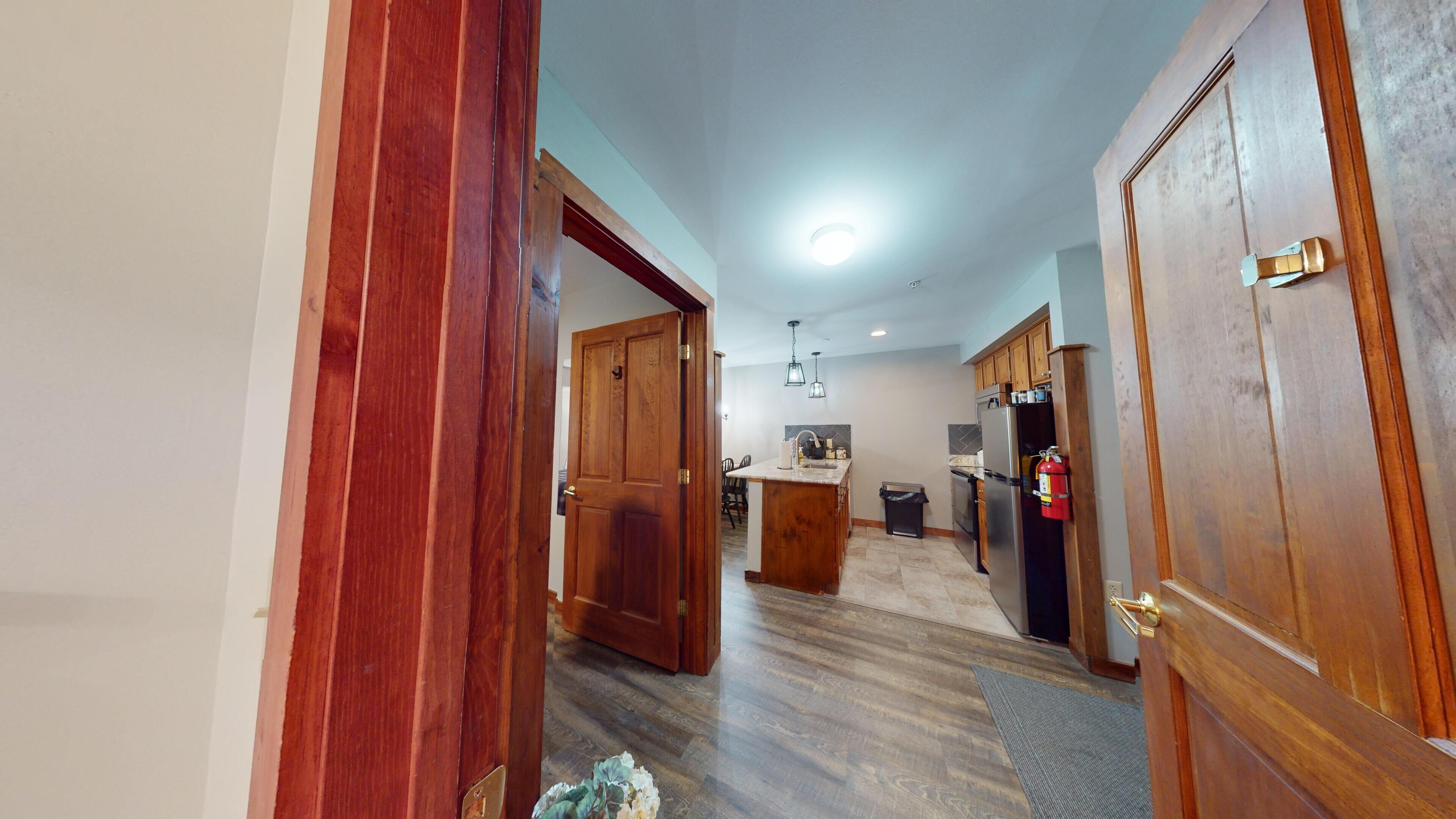 Una cocina con armarios de madera, un refrigerador de acero inoxidable y una salpicadera de azulejos.
