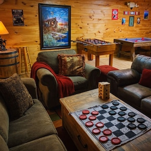 A cozy room with a foosball table, a checkered board game, and a framed picture on the wall. - Blue Ridge Mountain Cabin w/ Hot Tub, Firepit, Game Room & Scenic Views (Blue Ridge)