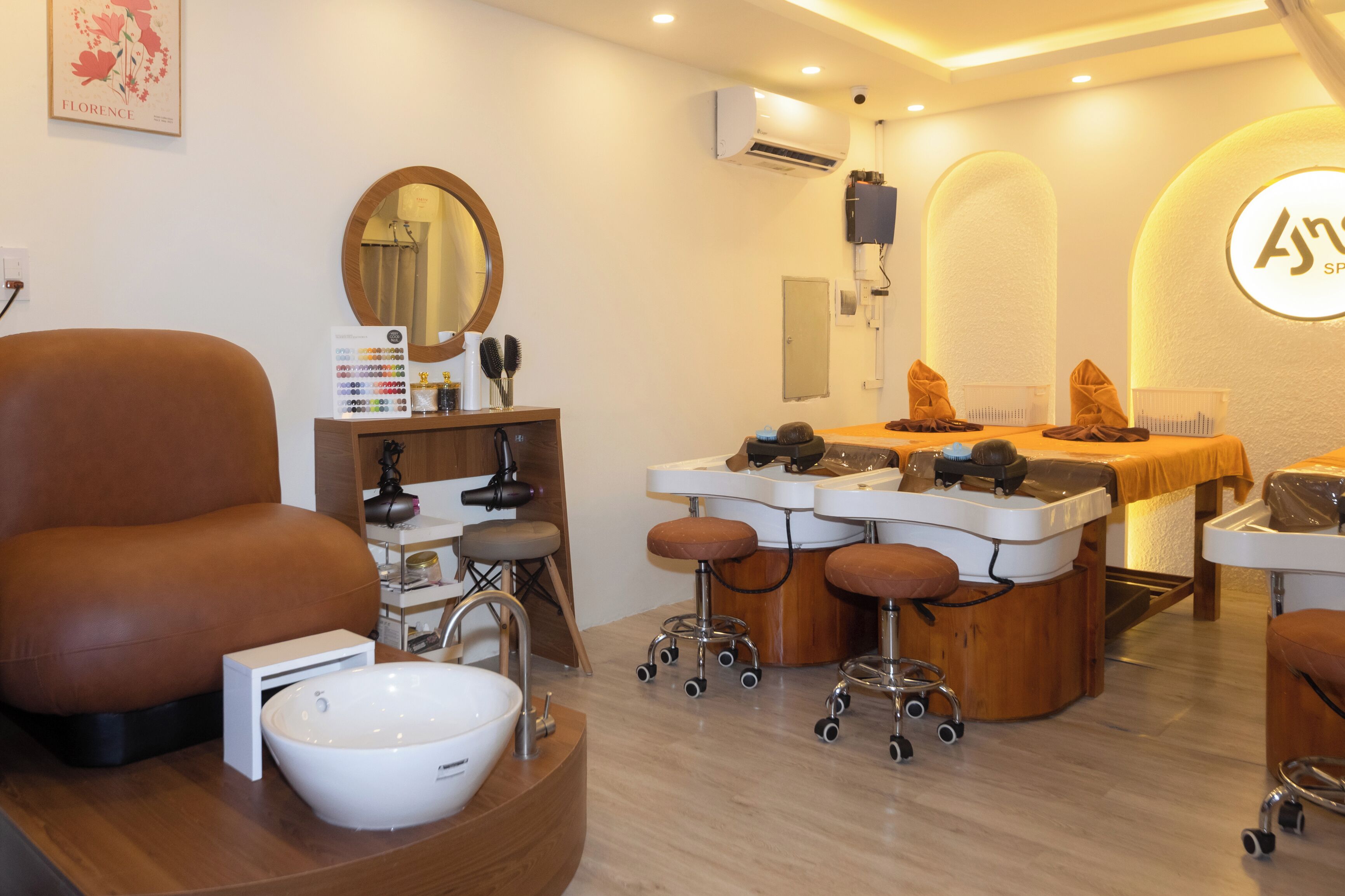 A modern salon with a large mirror, multiple sinks, and a comfortable seating area.