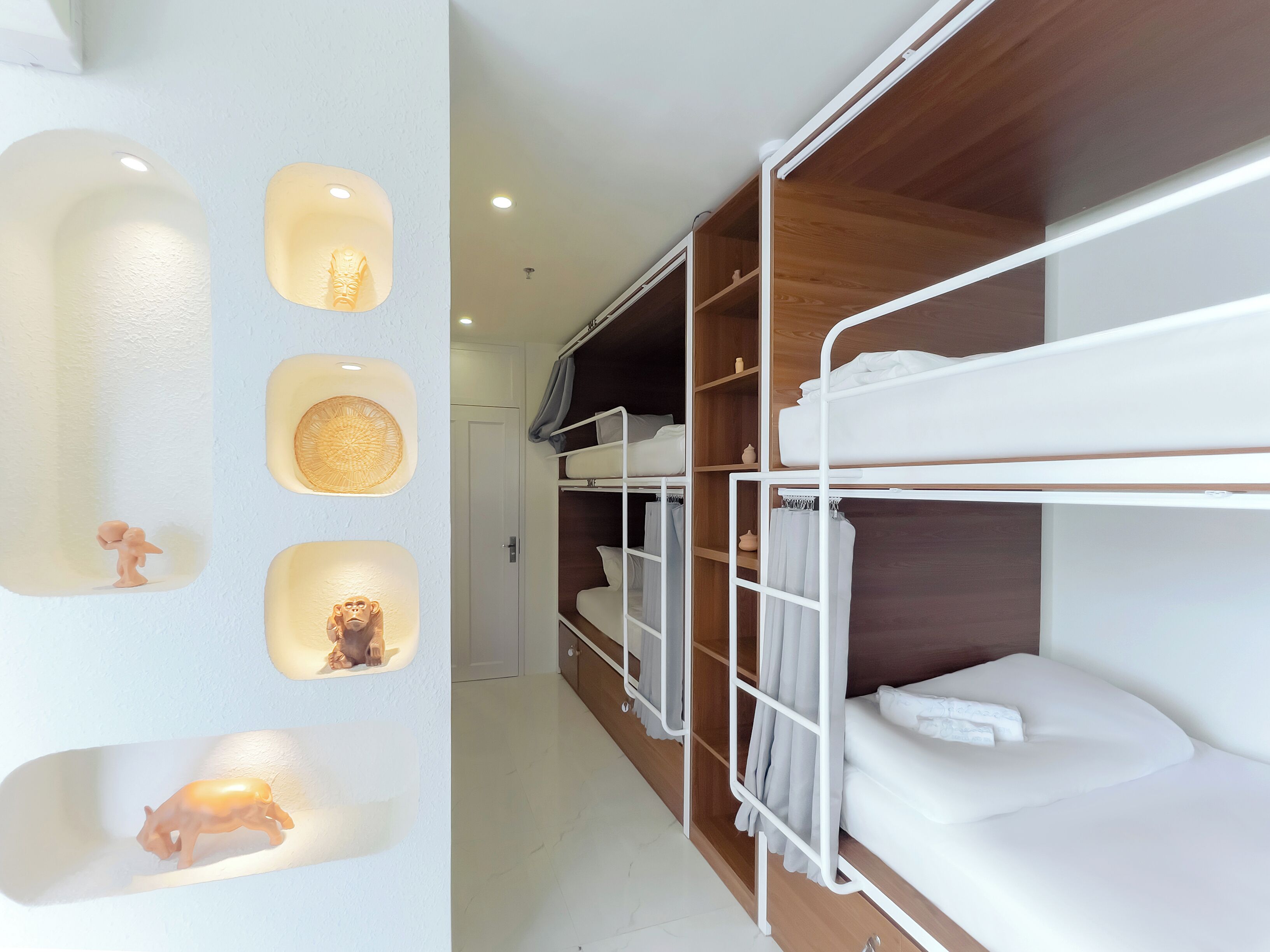 A bunk bed room with built-in shelves and wall-mounted lights.
