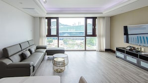 A modern living room with a sofa, coffee table, and TV. - Centum Converntion Hotel (Busan)