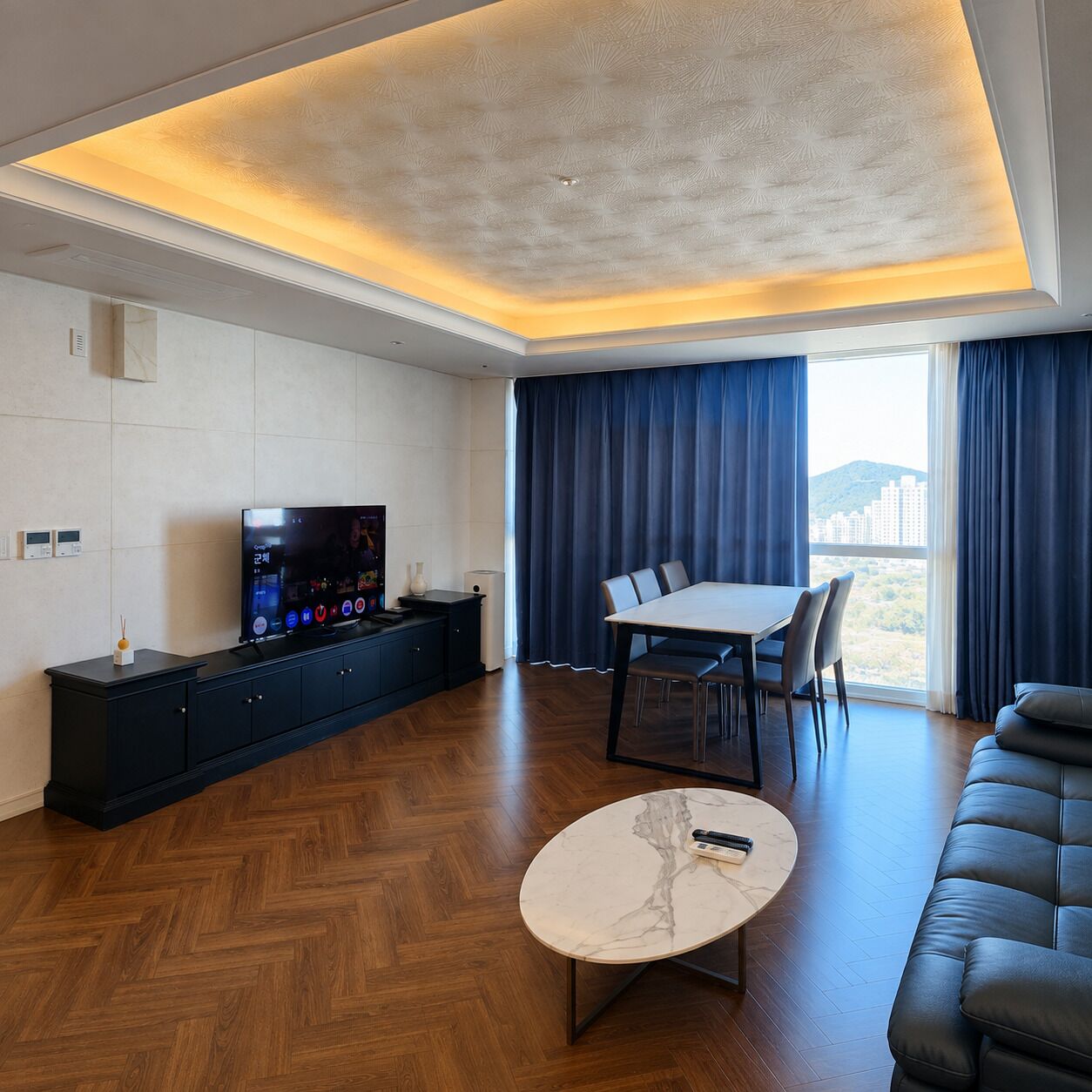A modern living room with a television, a dining table, and a sofa.