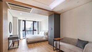 A modern hotel room with a bed, a sofa, a desk, and a wardrobe. - Centum Converntion Hotel (Busan)