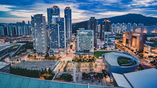 A modern cityscape with high-rise buildings, a curved architectural structure, and a well-organized urban layout. - Centum Converntion Hotel (Busan)