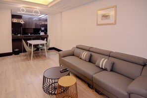 Suite Premium, varias camas | Zona de estar | Televisión de pantalla plana de 43 pulgadas con canales por cable