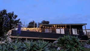 A modern building with a wooden deck and string lights. - Sun-drenched with spectacular views. Central location for exploring Bruny. (Alonnah)