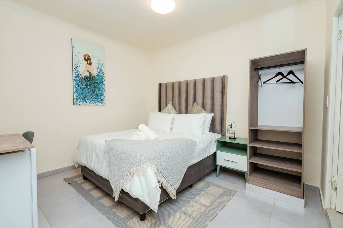 Un dormitorio con cama, mesita de noche y armario empotrado.