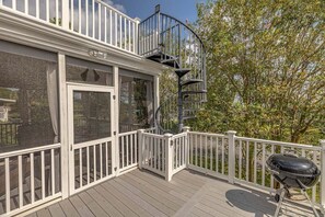 A deck with a white railing, a spiral staircase, and a barbecue grill. - Near the Beach, Village, Pier, Shops & Restaurants (Saint Simons Island)