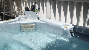 A hot tub with a metal ladder, a bucket, and bottles of champagne. - The Haven’s hideaway (Freeport)