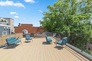 A rooftop deck with outdoor seating and a view of surrounding buildings. - Stylish Downtown Mall Loft with Rooftop (Charlottesville)