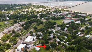 Vista aérea de una zona residencial con una flecha roja destacada que señala una casa en particular.