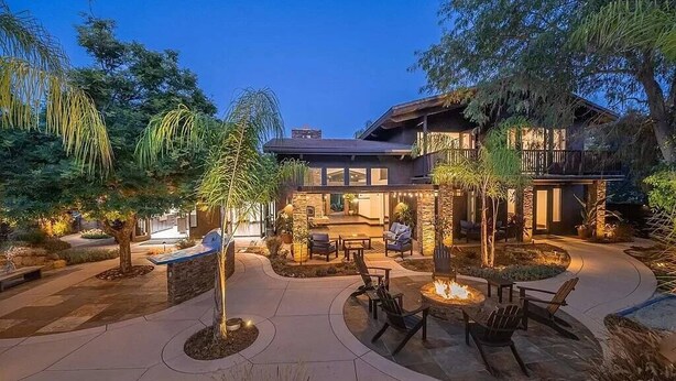 A modern house with a patio area featuring outdoor seating and a fire pit. - Resort-Style 5 BR Retreat in Lake Hodges W Pool, Jacuzzi, Grill, Volleyball Court (Escondido)