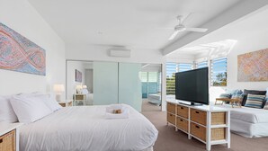 Una moderna camera d'albergo con un letto grande, una TV e un balcone vista.