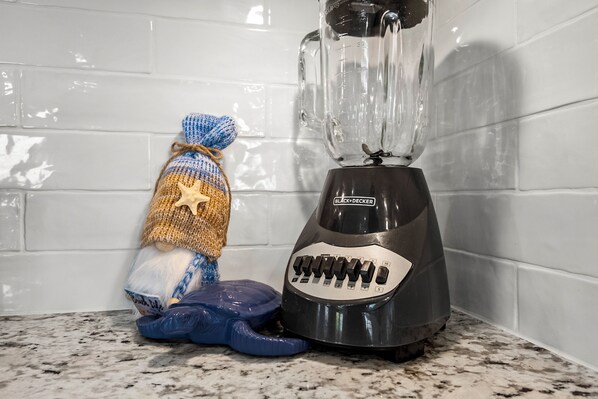Una cocina con una licuadora y una figurita decorativa de gnomo.