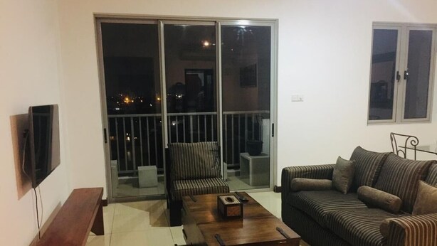 Ein Wohnzimmer mit einer Couch, einer Bank, einem Couchtisch und einem Fernseher.