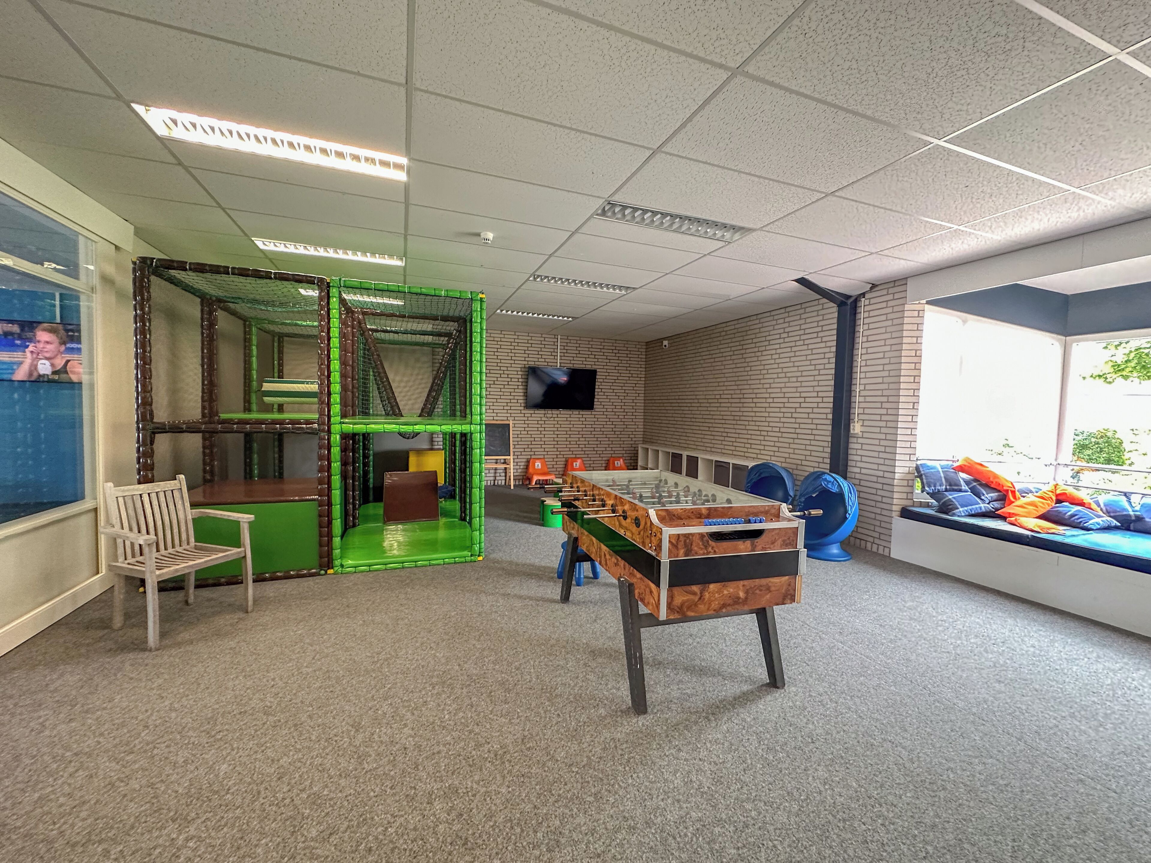 A play area with a climbing structure, a foosball table, and a seating area with a view.