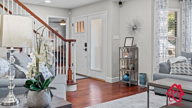 Un salon avec un escalier, une table basse, un canapé et une étagère décorative.