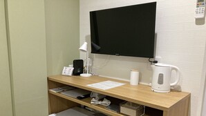 Un espacio de trabajo compacto con escritorio, silla y un refrigerador pequeño.