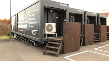 A trailer hotel with labeled rooms including twin, triple, dormitory, and pet rooms.