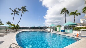 A swimming pool with clear blue water, surrounded by palm trees and lounge chairs. - 18th Fl Ilikai Hotel Condo | King Bed | Valet Parking | City View (Honolulu)