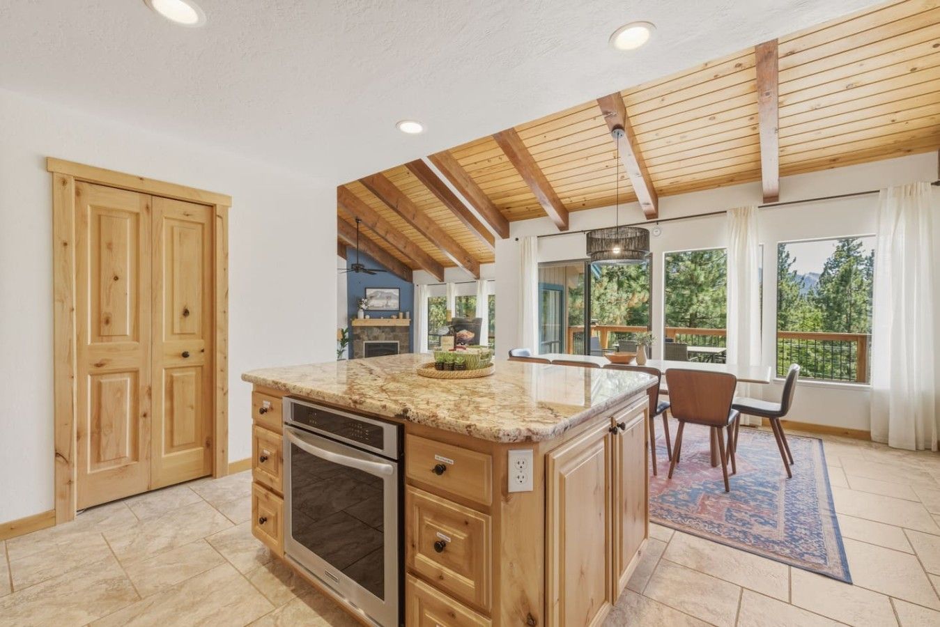 A kitchen with wooden cabinets, a granite countertop, and a built-in oven.