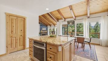 A kitchen with wooden cabinets, a granite countertop, and a built-in oven.