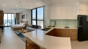 Une chambre d’hôtel moderne équipée d’un lit, d’un canapé et d’une kitchenette.