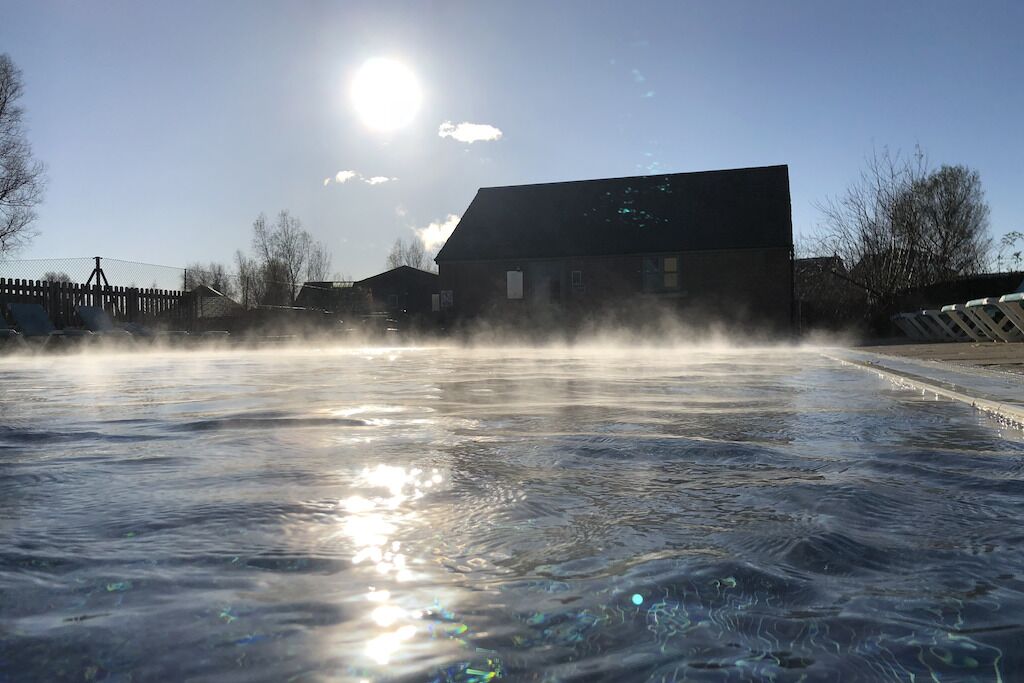 A swimming pool with a clear sky and a building in the background.
