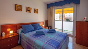 Ein Hotelzimmer mit Bett, Nachttischen, einem Kleiderschrank und einem Balkon mit Blick.