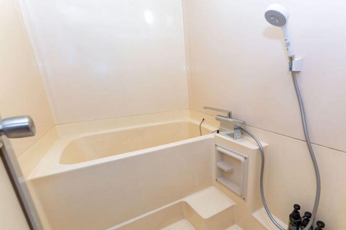 Une salle de bain équipée d’une baignoire, d’une douche et d’un porte-serviettes.