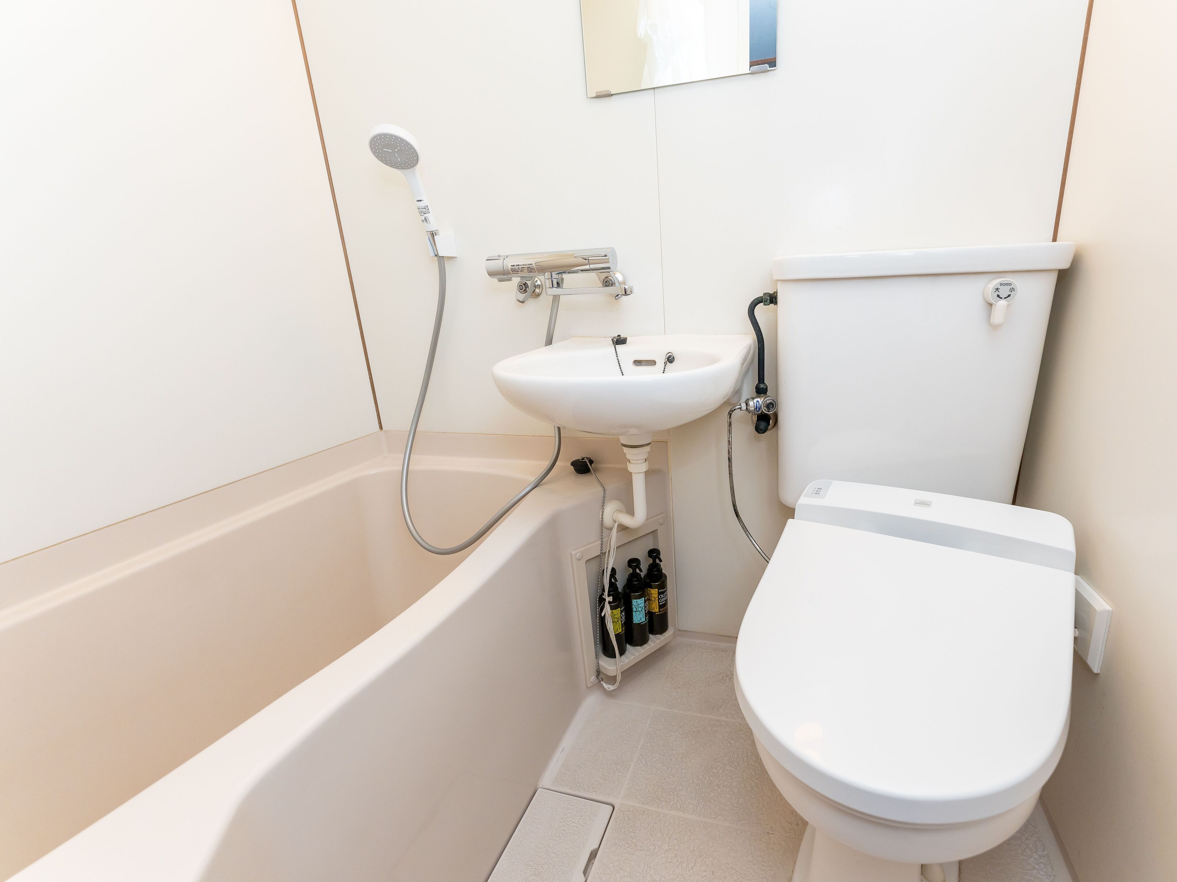 A compact bathroom with a bathtub, a sink, and a toilet.