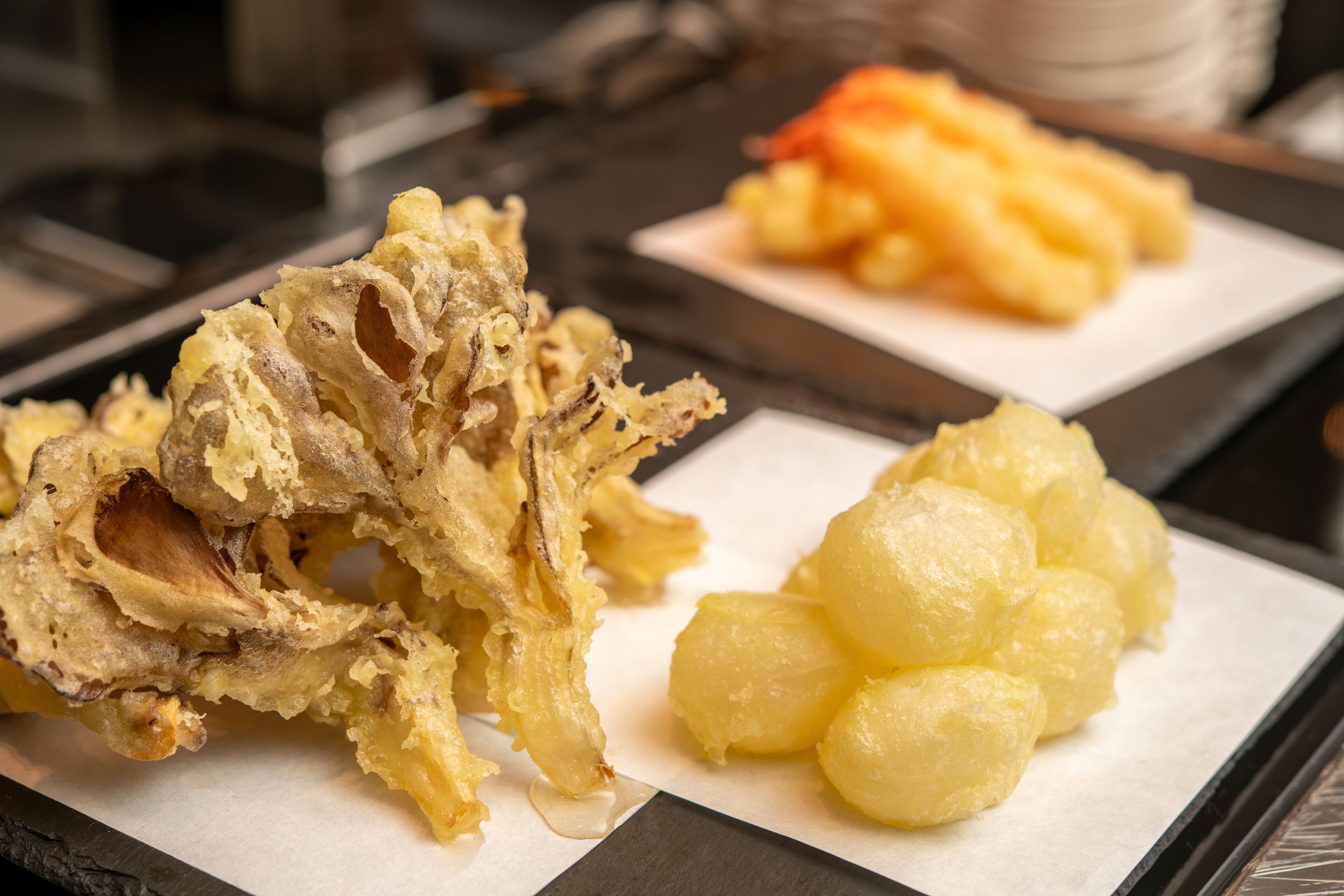 A tray with fried food items and a plate of potato dumplings.