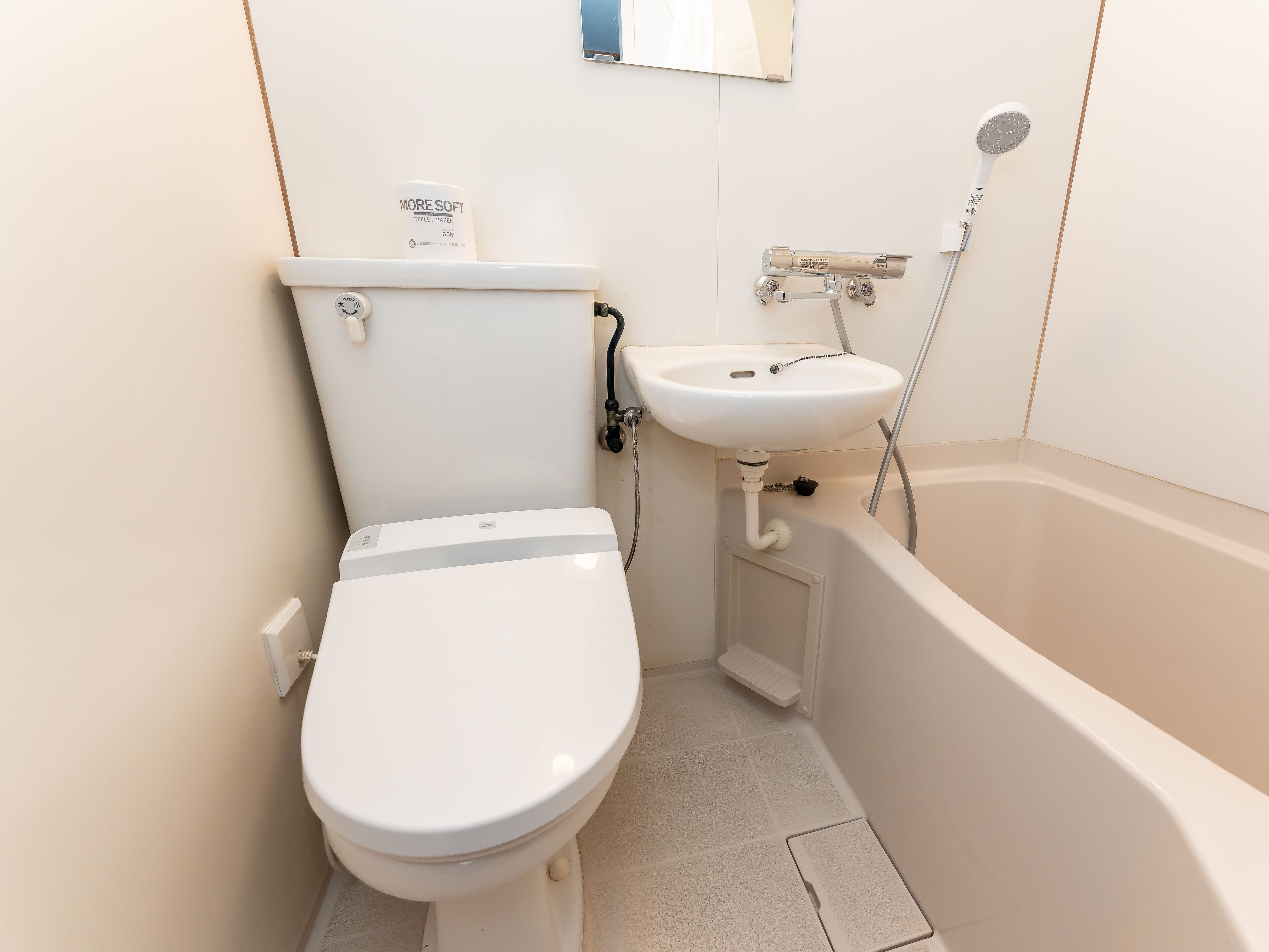 A compact bathroom with a toilet, sink, and bathtub.