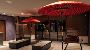A modern interior with seating areas, large windows, and a traditional Japanese aesthetic.