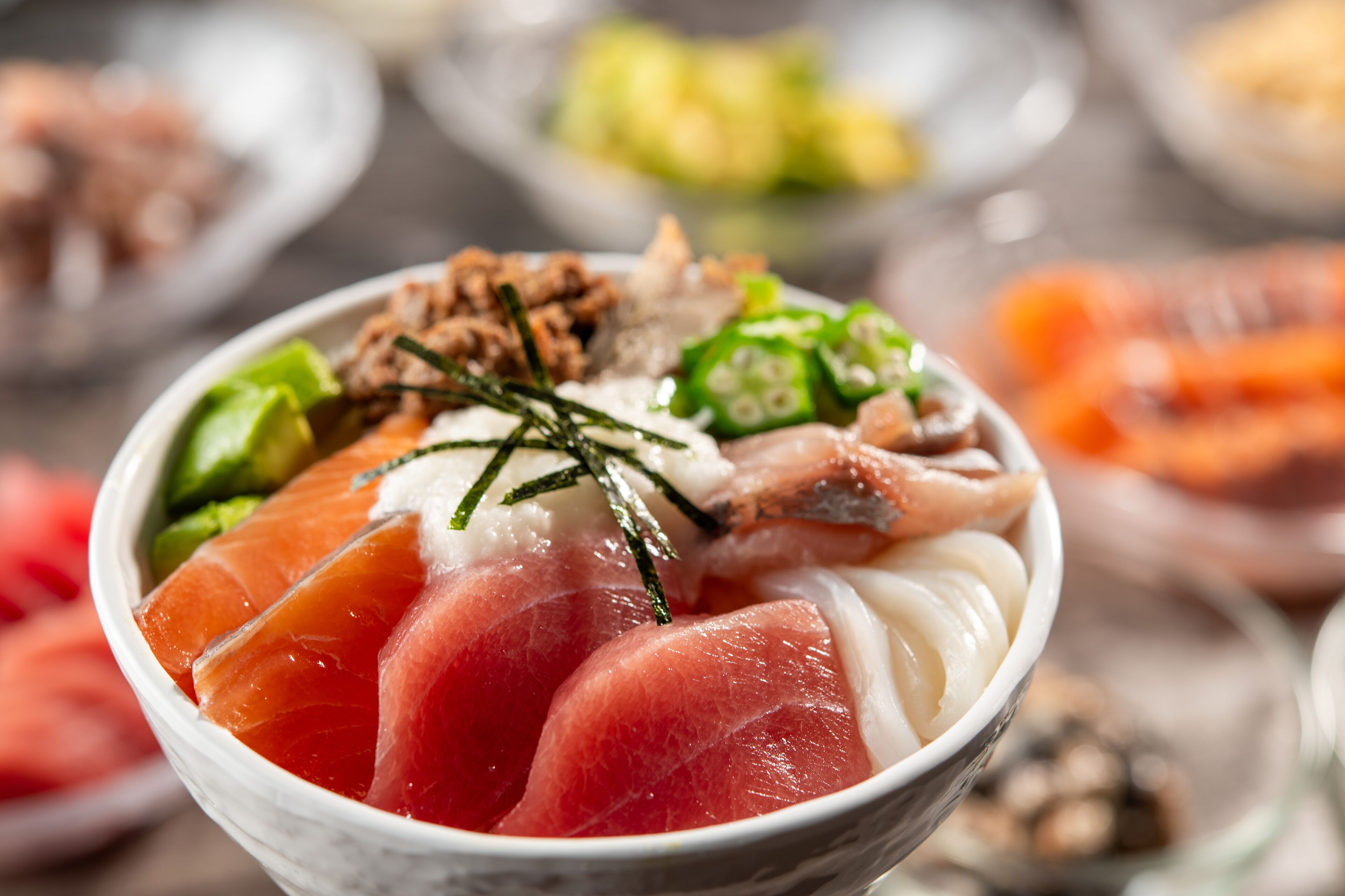 A bowl of sashimi with various toppings.