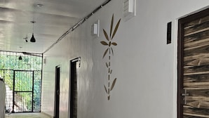 Um corredor com piso de azulejos, design decorativo na parede e uma grande porta de madeira.