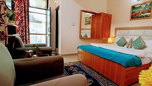 Un dormitorio con cama, una silla, un escritorio y una ventana con cortinas.