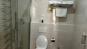 A bathroom with a glass-enclosed shower, a toilet, a bidet, and a sink. - Hotel 26 (Milan)