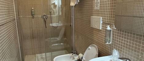 A bathroom with a shower, toilet, and sink.
