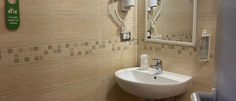 A bathroom with a sink, mirror, towel rack, and a trash bin.