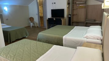 Ein Hotelzimmer mit zwei Betten, einem Schreibtisch, einem Stuhl, einem Fernseher und einem Kleiderschrank.