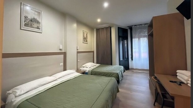 A hotel room with two single beds, a desk, and a chair. - Hotel 26 (Milan)